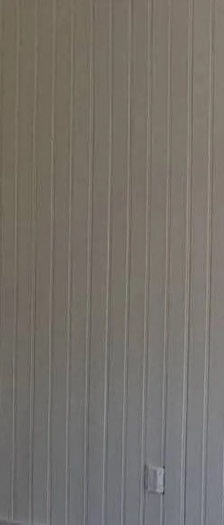 Närbild på målad panelvägg i varmgrått