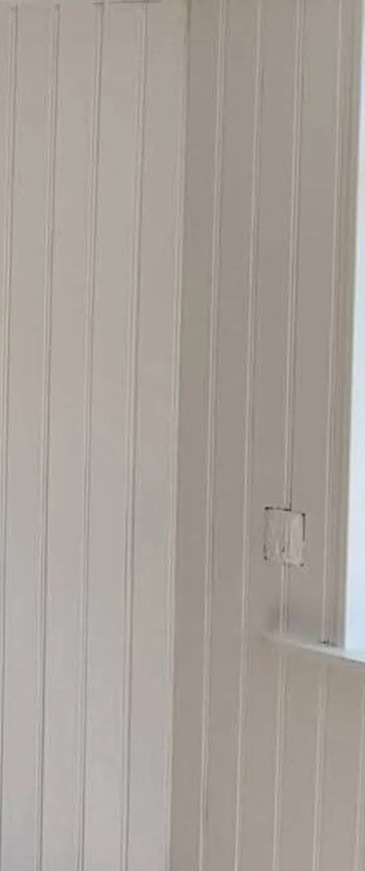 Nymålad ljus panelvägg i ett hörn med fönsterbänk, målad av K&M Måleri